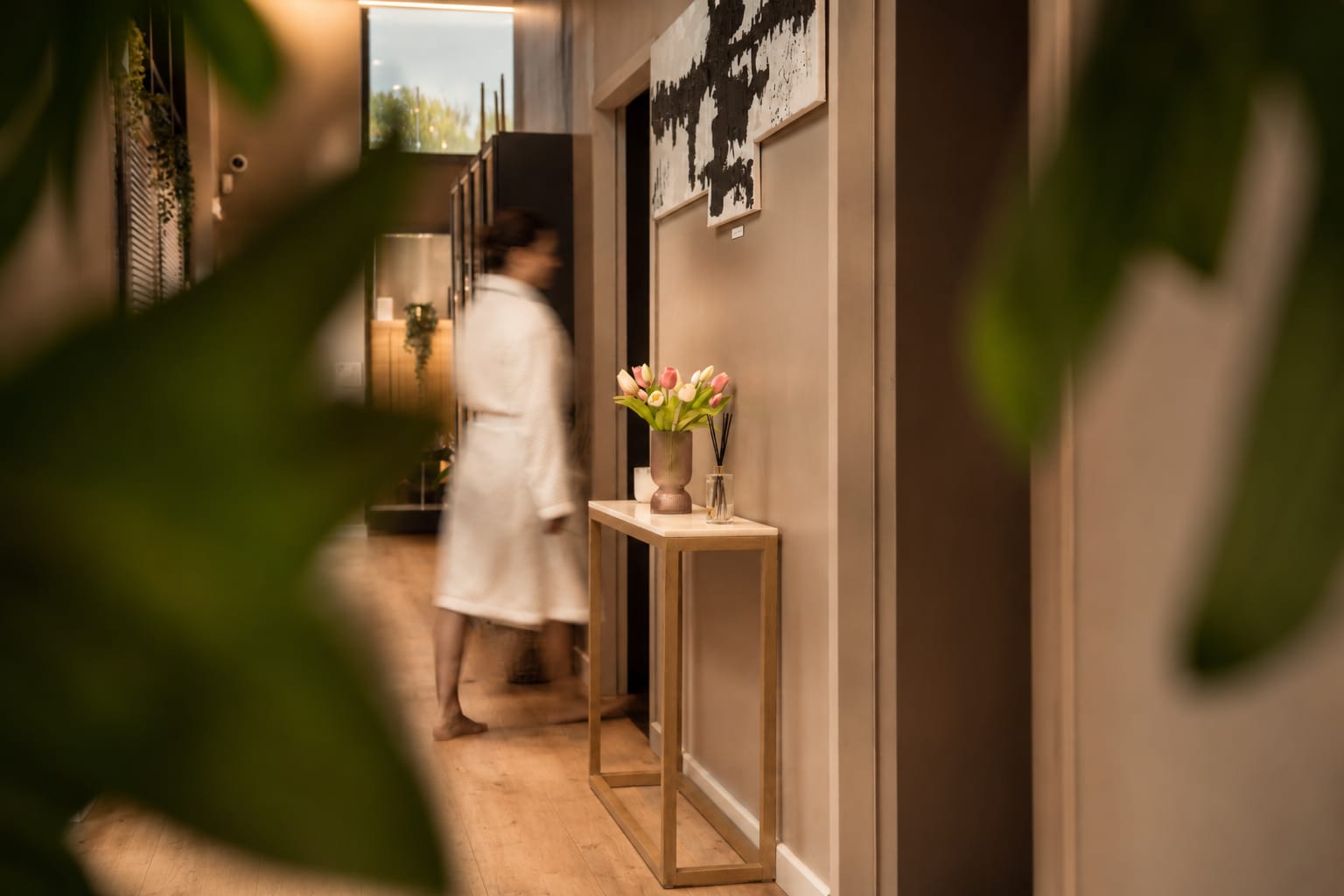 Le couloir des Bains d'Hygie vu à travers les feuillages — silhouette rejoignant sa cabine